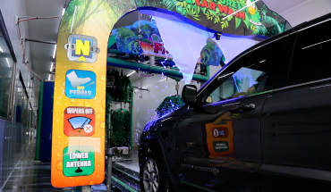 Vehicle moving through tunnel in brightly lit car wash